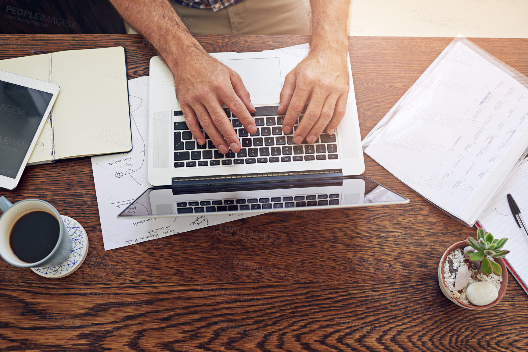 Buy stock photo High angle shot of a man sitting at a desk working on a laptop