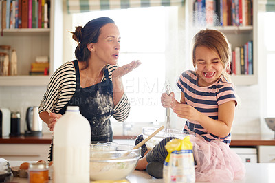 Buy stock photo Shot of a little girl baking with her mother in the kitchen