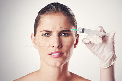 Buy stock photo Woman, forehead and hand with syringe or glove for dermatology or skincare on a white studio background. Portrait, person and plastic surgery with needle for medical aesthetic, filler or facial