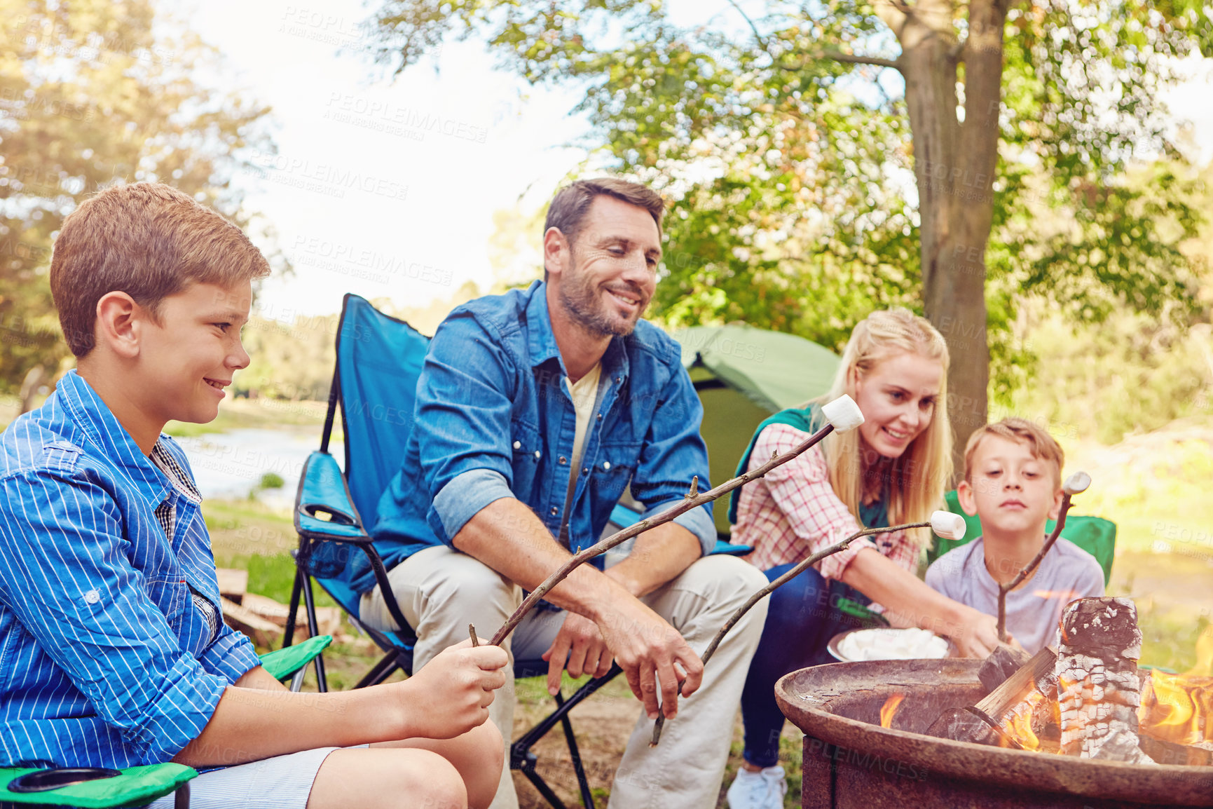 Buy stock photo Cropped shot of a family of four camping in the woods