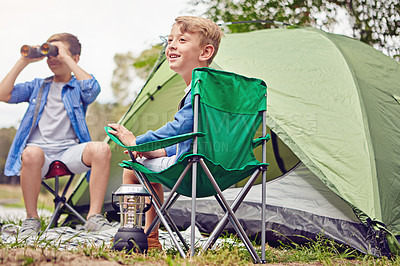 Buy stock photo Shot of two young brothers sitting at their campsite