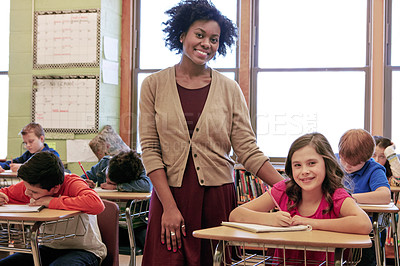 Buy stock photo Education, learning and portrait of teacher with girl writing exam or test at Montessori school with students. Black woman, happy children at desk and monitoring growth and development for school kid