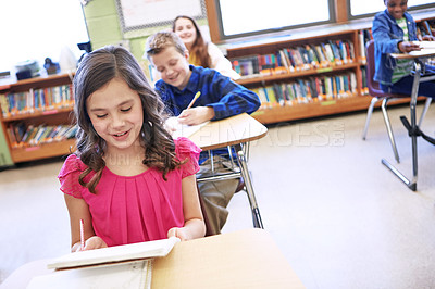 Buy stock photo Shot of a group of elementary school children sitting in a classroom