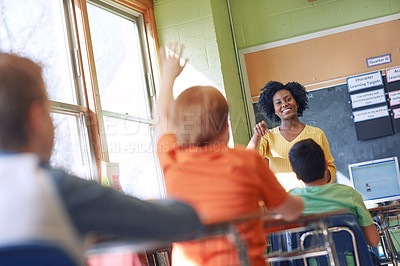 Buy stock photo Shot of a young boy raising his hand to answer his teacher's question