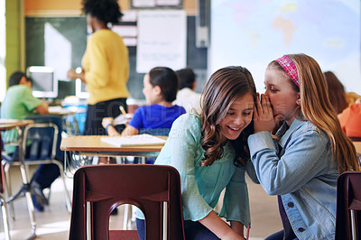 Buy stock photo Friends, whisper and gossip in classroom for secret, talking or chatting during teaching lesson. Sneaky female learners sharing quiet information secretly in ear at class while teacher is busy