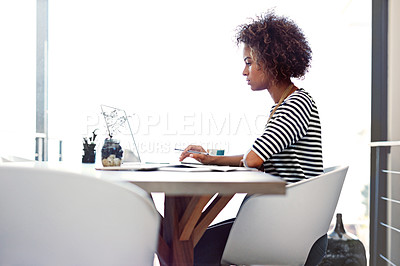 Buy stock photo Shot of a young woman working on a laptop at home