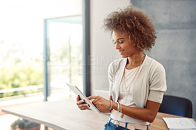 Buy stock photo Shot of a young woman working at home with a digital tablet