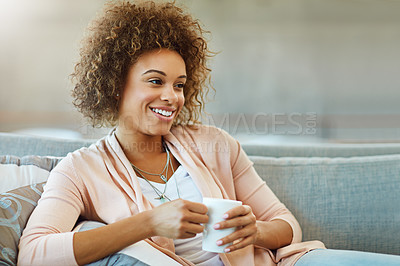 Buy stock photo Shot of a young woman relaxing with a warm beverage at home