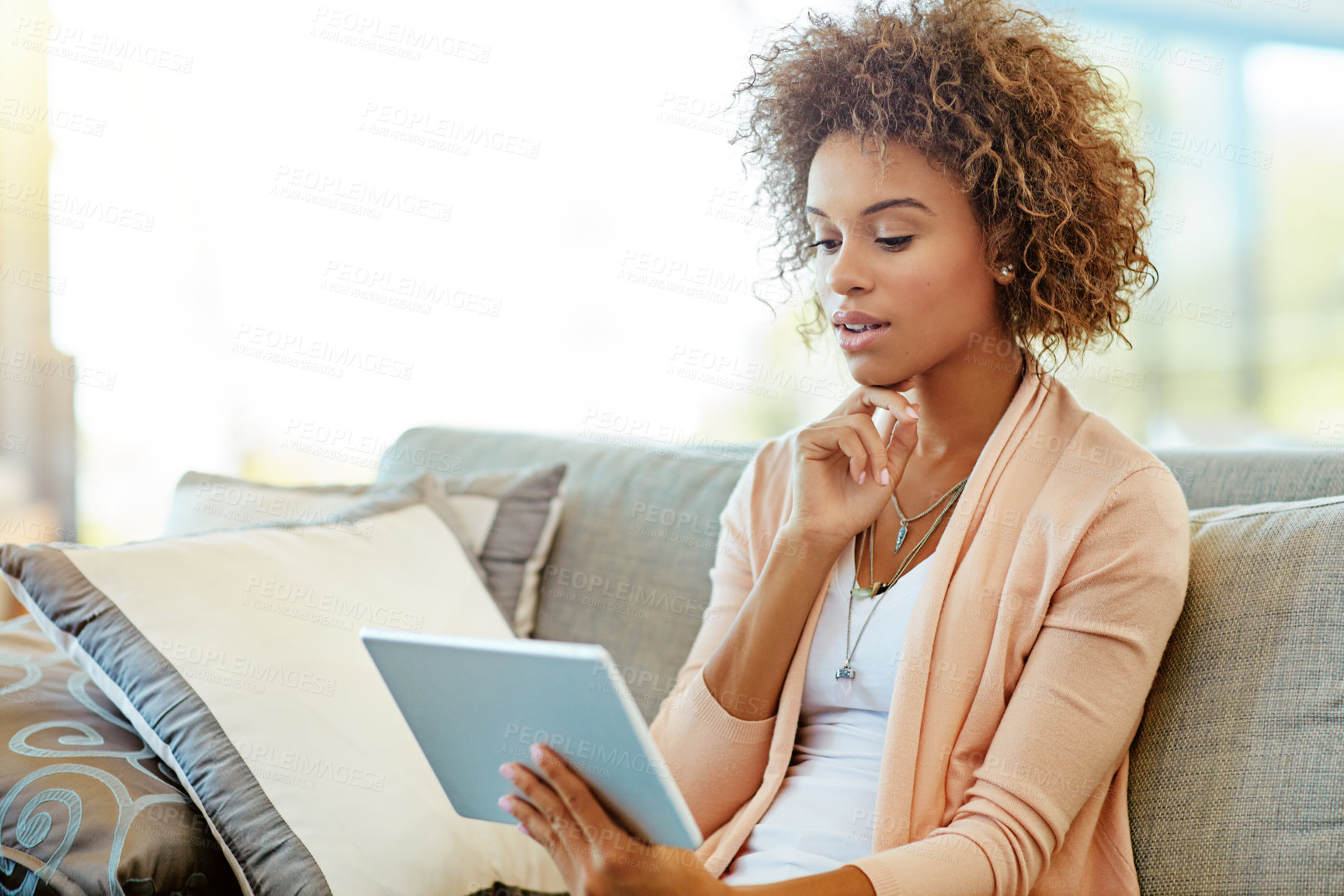 Buy stock photo Shot of a young woman using a digital tablet at home