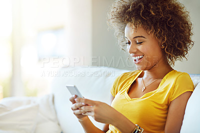 Buy stock photo Shot of a young woman using her phone on a relaxing day at home