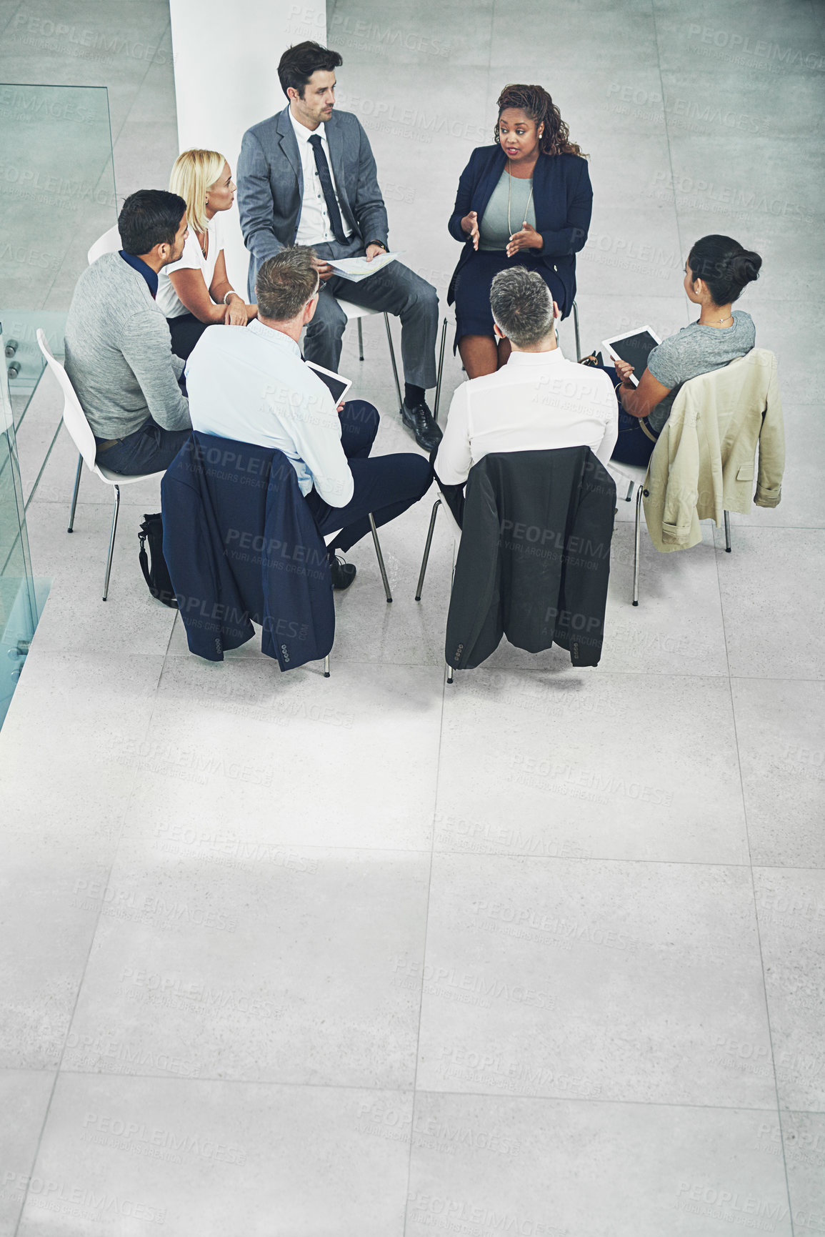 Buy stock photo High angle shot of a group of coworkers talking together while sitting in a circle in an office