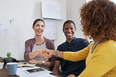 Buy stock photo Shot of coworkers shaking hands during a meeting in a modern office