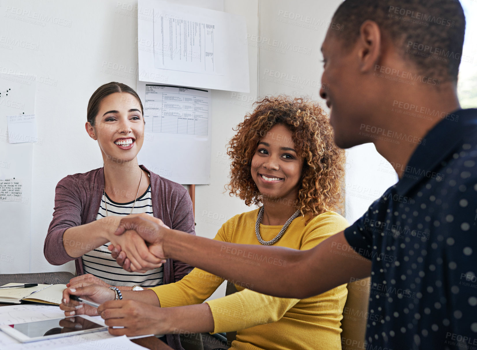 Buy stock photo Shot of coworkers shaking hands during a meeting in a modern office