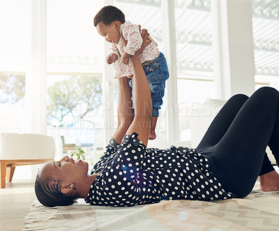 Buy stock photo Shot of a mother holding her baby girl up in the air