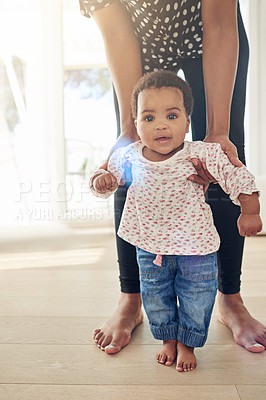 Buy stock photo Portrait of a smiling baby girl standing with the support of her mother