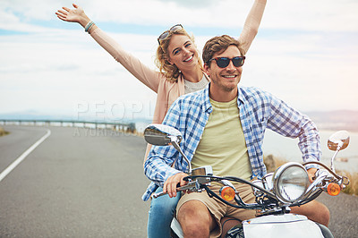 Buy stock photo Shot of a young couple out for a ride on a scooter