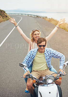 Buy stock photo Shot of a young couple out for a ride on a scooter