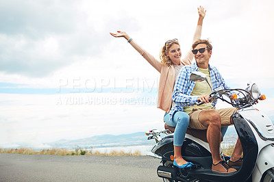 Buy stock photo Shot of a young couple out for a ride on a scooter