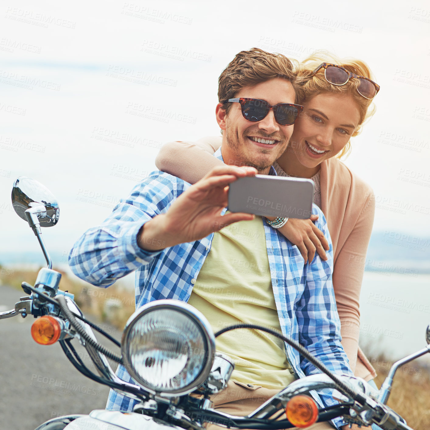 Buy stock photo Shot of a couple taking a selfie while out on a road trip with a scooter