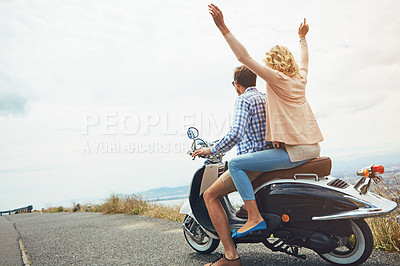 Buy stock photo Shot of a young couple out for a ride on a scooter