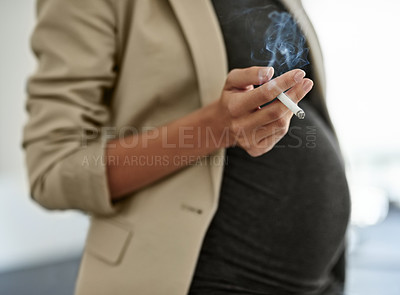 Buy stock photo Shot of a woman smoking a cigarette while preganant