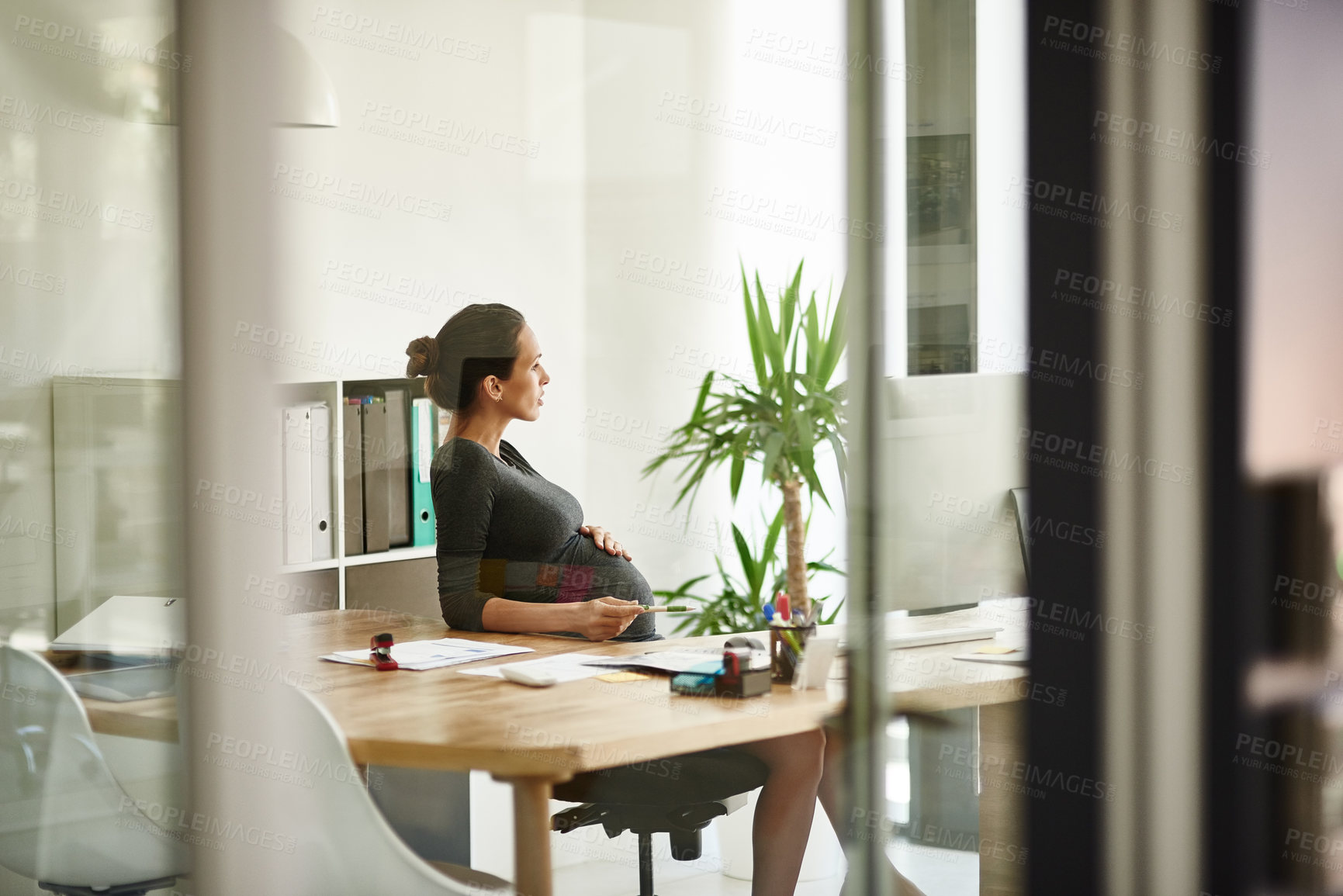 Buy stock photo Shot of a pregnant businesswoman sitting in her office