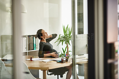 Buy stock photo Shot of a pregnant businesswoman sitting in her office