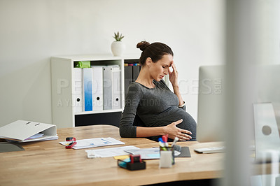 Buy stock photo Shot of a pregnant businesswoman in discomfort in her office