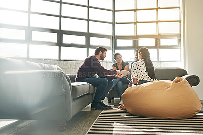 Buy stock photo Shot of a team of colleagues having a meeting on a sofa in a modern office