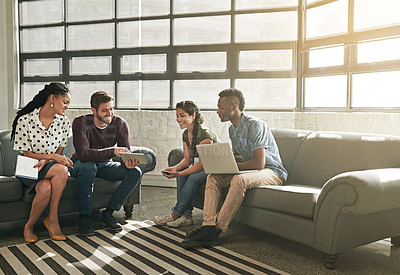 Buy stock photo Shot of a team of colleagues having a meeting on a sofa in a modern office