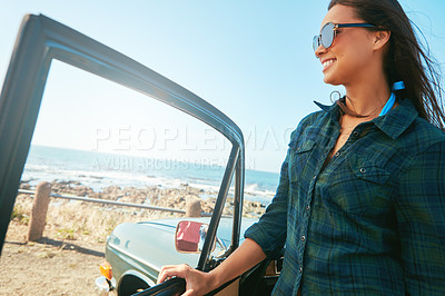 Buy stock photo Shot of a young woman on a road trip near the ocean