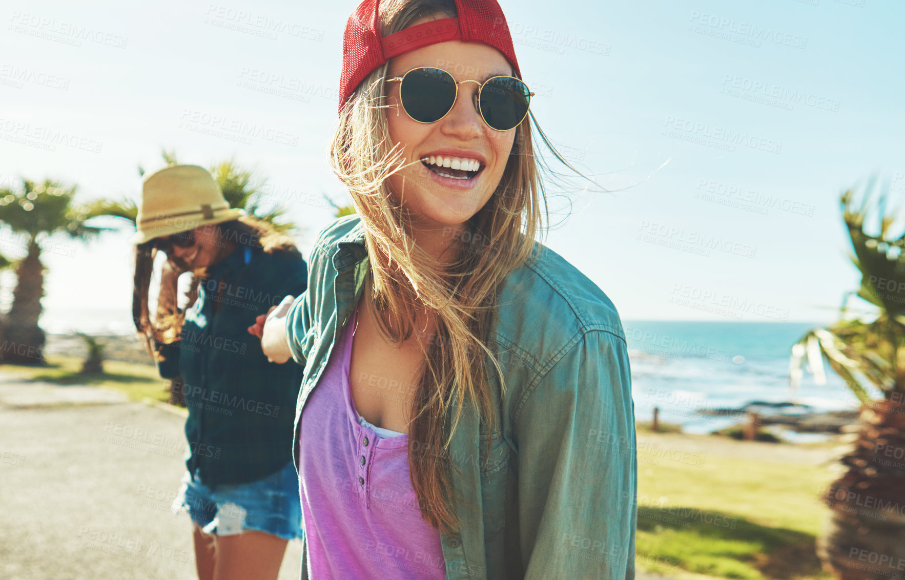 Buy stock photo Shot of two friends hanging out on the boardwalk