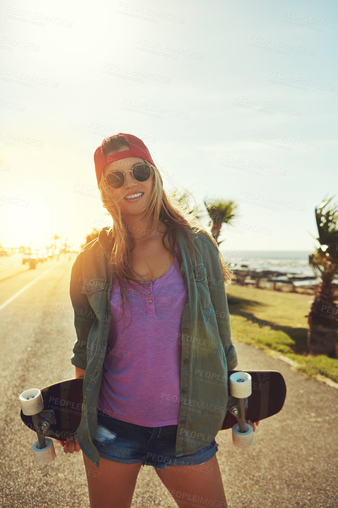 Buy stock photo Shot of a young woman hanging out on the boardwalk with her skateboard