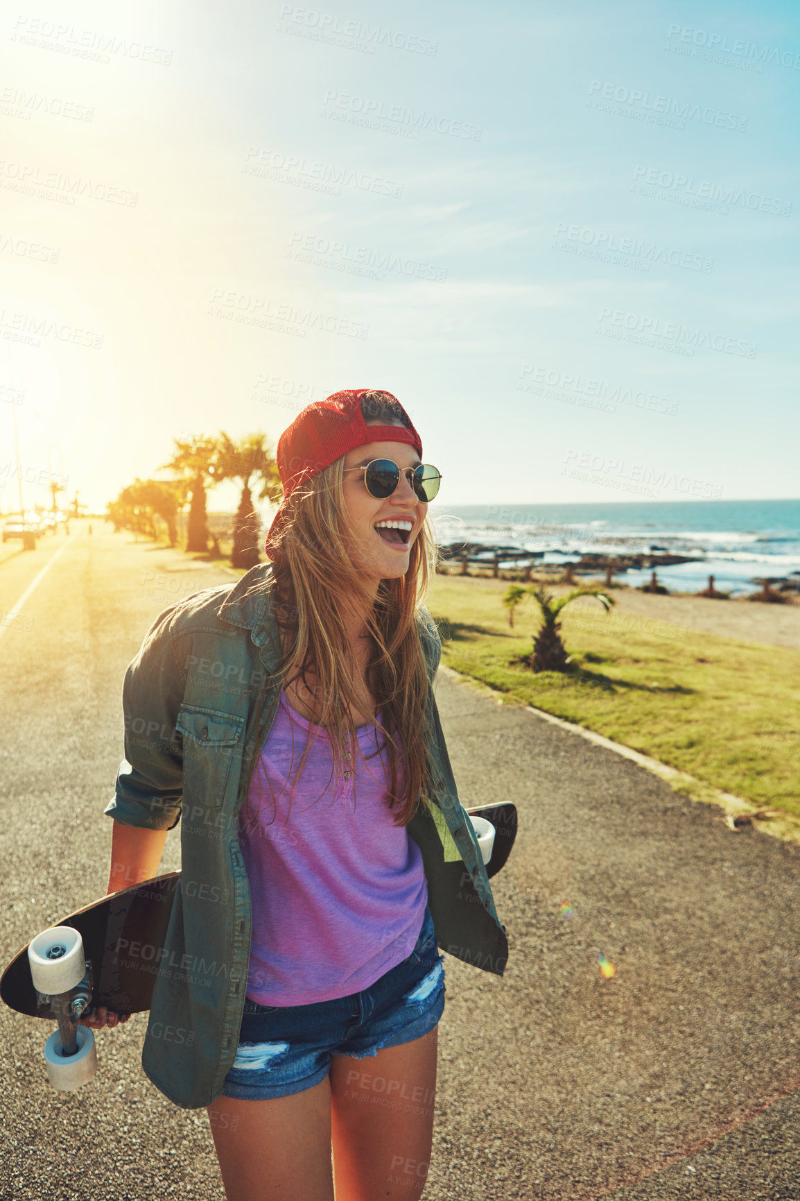 Buy stock photo Shot of a young woman hanging out on the boardwalk with her skateboard