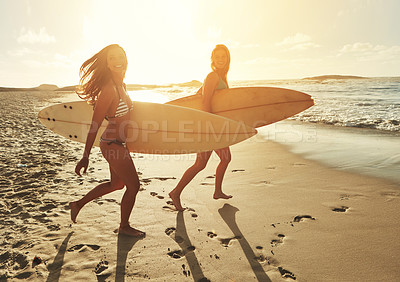 Buy stock photo Shot of two friends going surfing at the beach