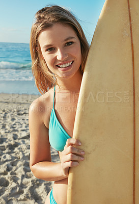 Buy stock photo Portrait of a young woman with a surfboard hanging out at the beach