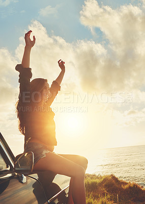 Buy stock photo Road trip, view and arms raised with a woman at the coast, sitting on her car bonnet during travel for freedom or escape. Nature, flare and water with a female tourist traveling in summer at sunset