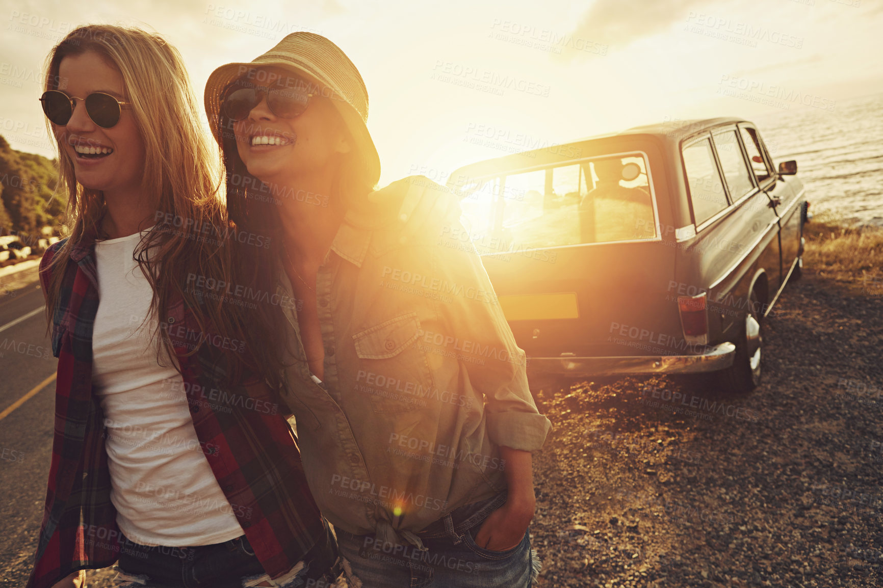 Buy stock photo Cropped shot of two friends on a road trip to the beach at sunset