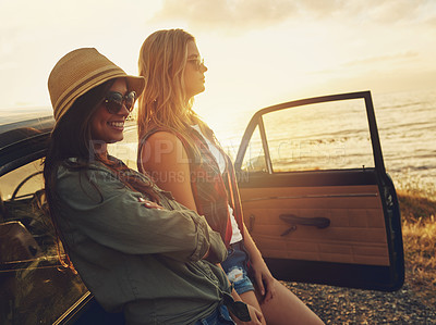 Buy stock photo Cropped shot of two friends on a road trip to the beach at sunset