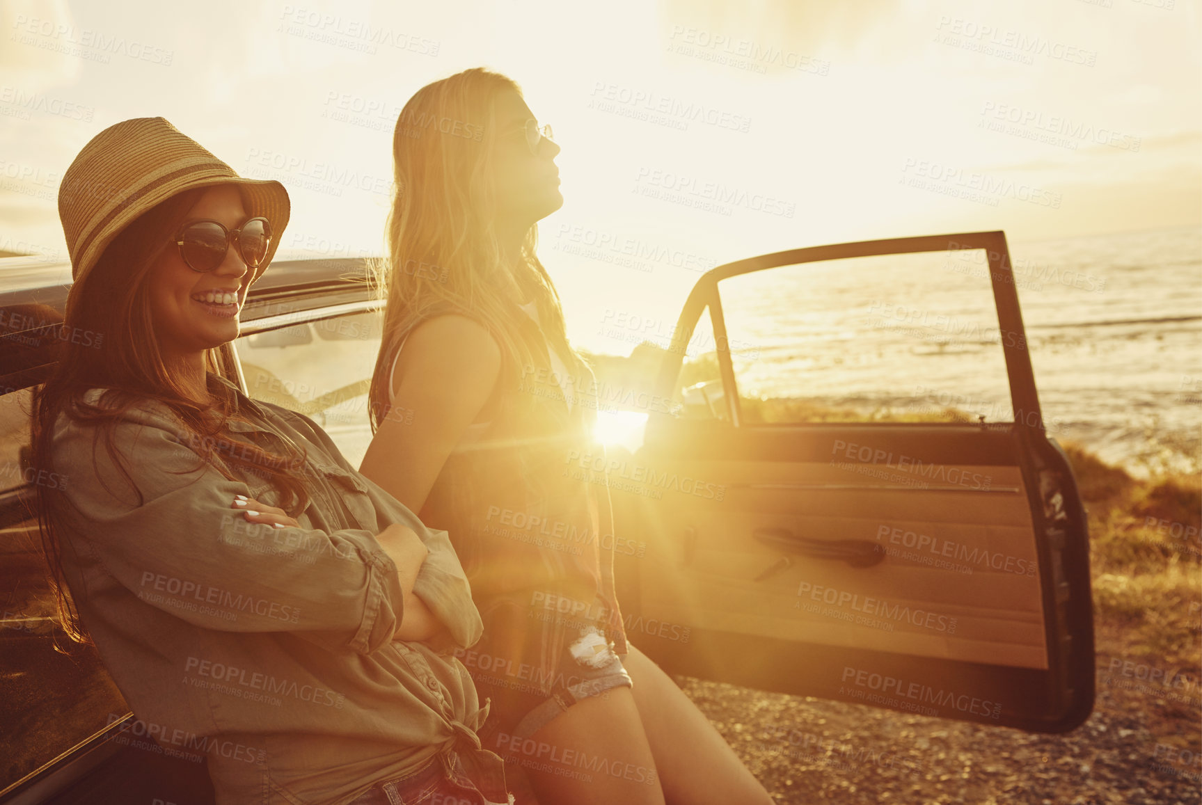 Buy stock photo Friends at sunset, women and car beach with travel and adventure on road trip, outdoor with nature and sea holiday. Happy people, freedom and gen z youth on summer vacation, happiness with lens flare