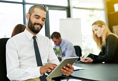 Buy stock photo Shot of a businessman using a digital tablet during a meeting in a boardroom