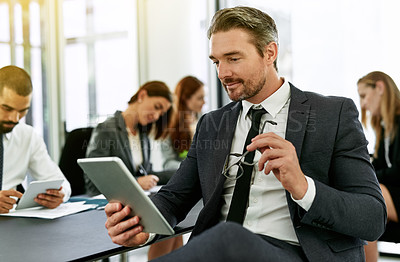 Buy stock photo Shot of a businessman using a digital tablet during a meeting in a boardroom