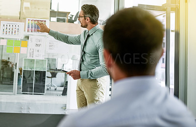 Buy stock photo Shot of a businessman giving a presentation to his colleague in an office