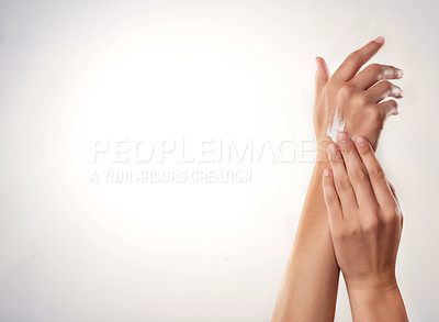Buy stock photo Closeup studio shot of a woman applying cream to her hands