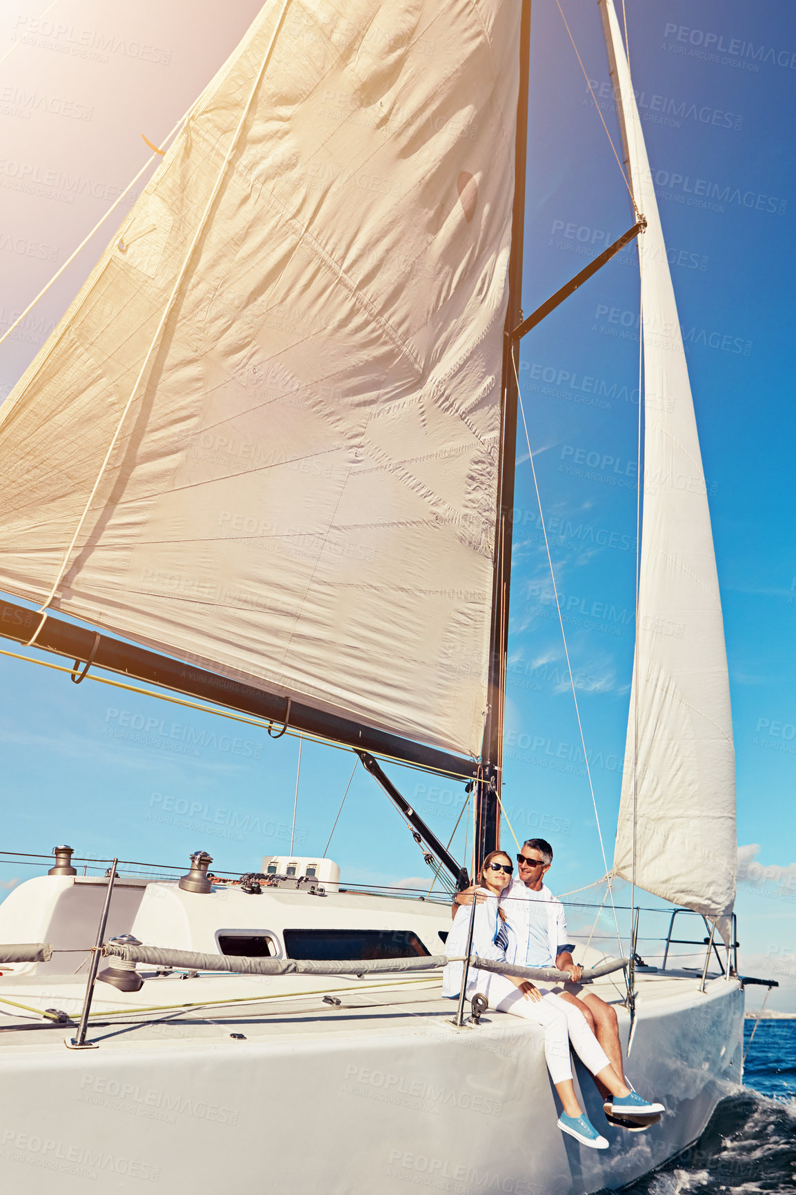 Buy stock photo Shot of a couple enjoying a boat cruise out on the ocean