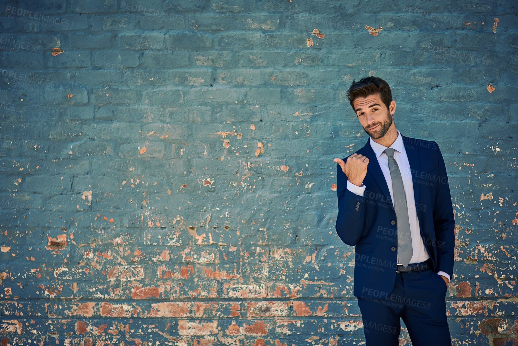 Buy stock photo Portrait of a young corporate businessman standing against a brick wall