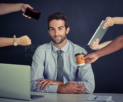Buy stock photo Portrait of a young corporate businessman sitting at a desk surrounded by hands reaching in with office items