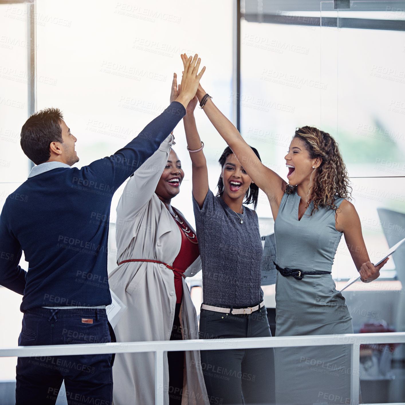 Buy stock photo Shot of a group of colleagues high fiving together in an office