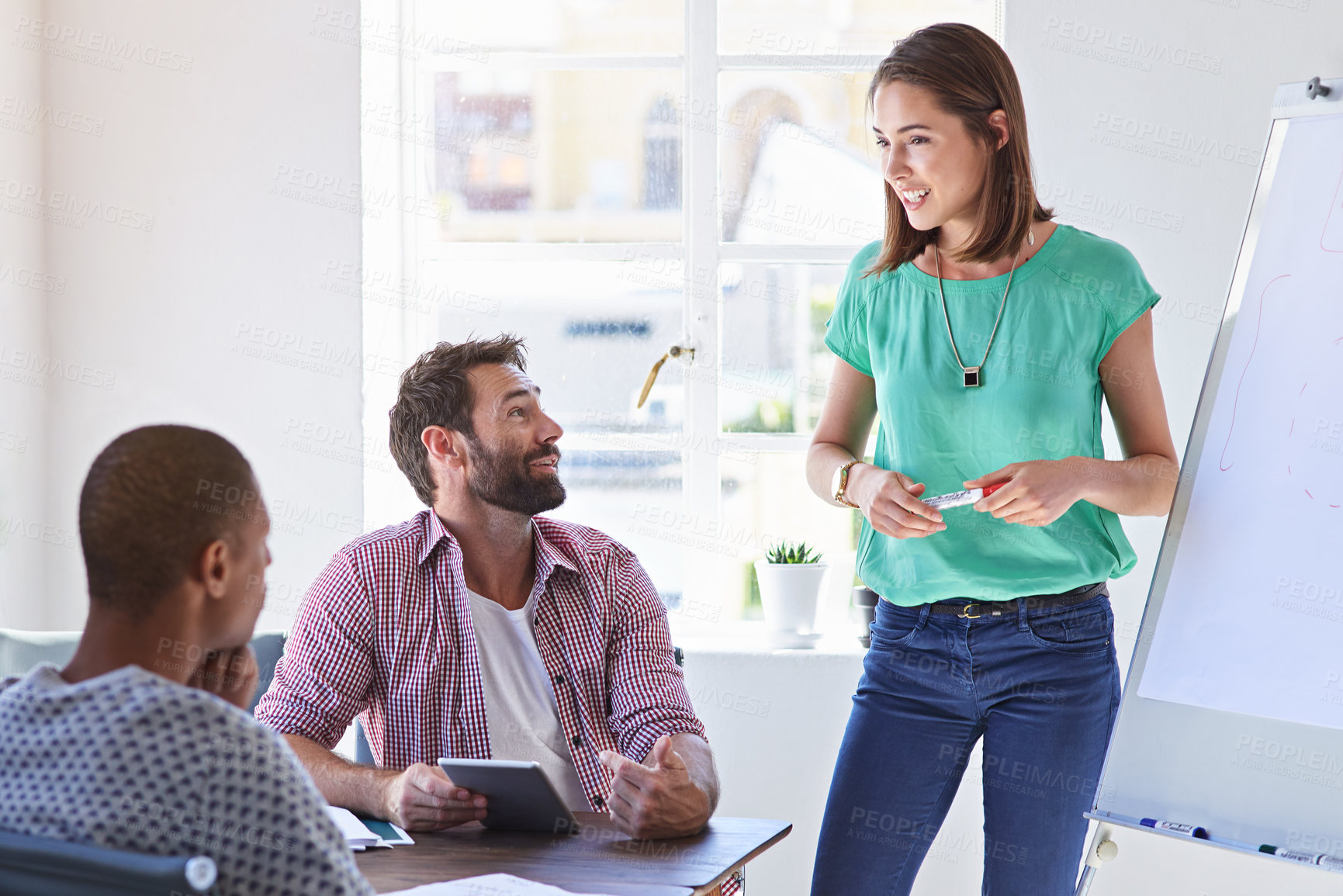 Buy stock photo Shot of a young businesswoman giving a presentation to her design team