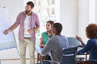 Buy stock photo Shot of a young businessman giving a presentation to his design team